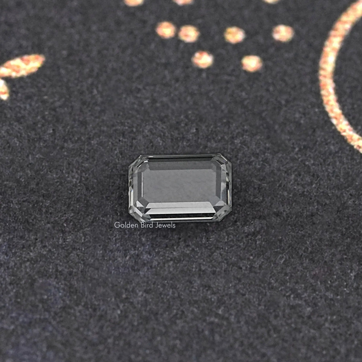 Emerald-cut loose diamond close-up, clear rectangular stone with stepped facets