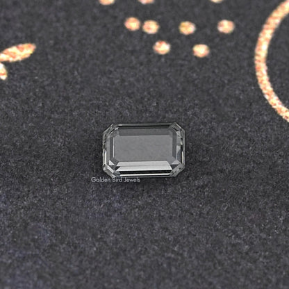 Emerald-cut loose diamond close-up, clear rectangular stone with stepped facets