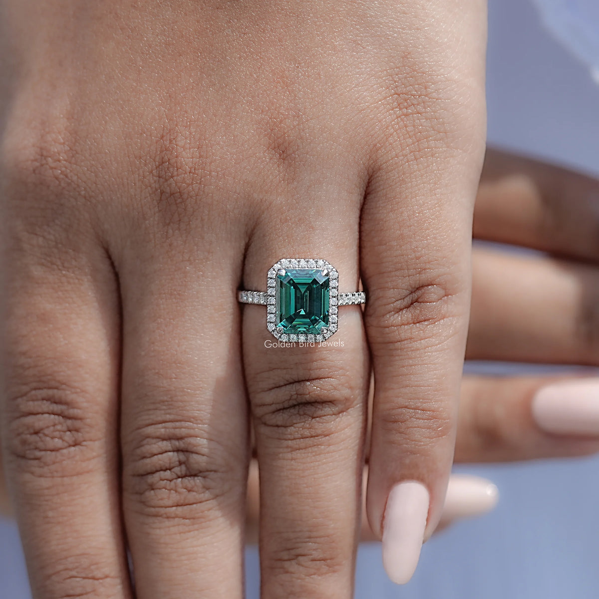 Green emerald-cut moissanite engagement ring on hand, pave sterling band