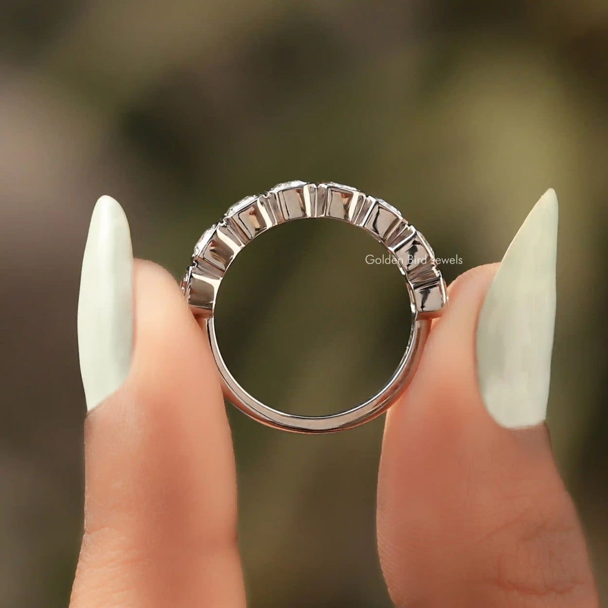 Silver half-eternity wedding band with bezel-set emerald-cut clear stones