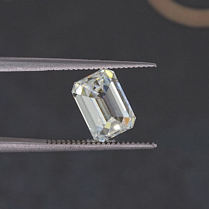 Near colorless emerald-cut moissanite loose stone shown at a side angle