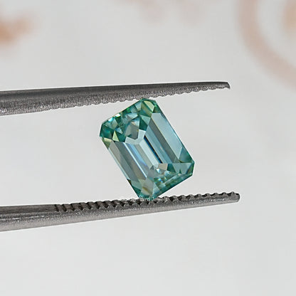 Emerald-cut teal-green moissanite loose stone with crisp step facets