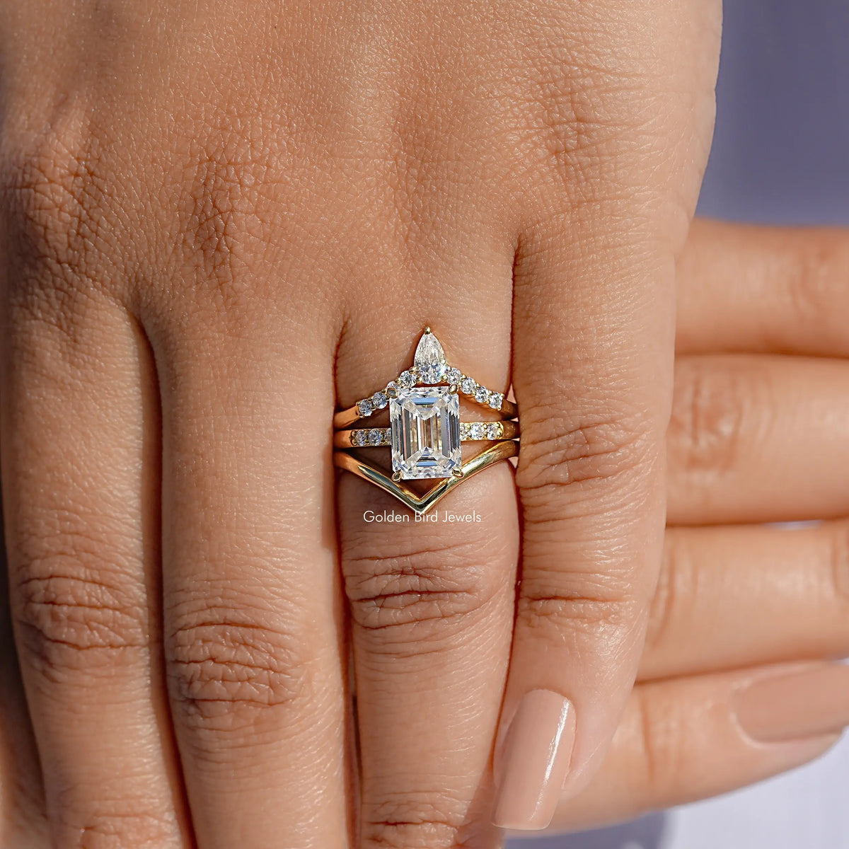 Three-stone bridal ring set with stacked curved bands and rectangular center stone