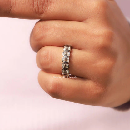 Silver half-eternity ring with bezel-set emerald-cut clear stones, close-up