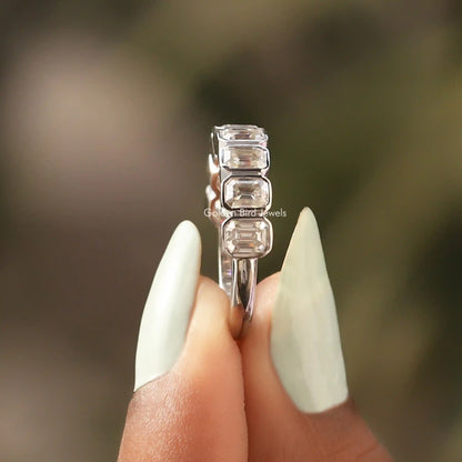 Silver half-eternity ring with emerald-cut clear stone bezels, side view