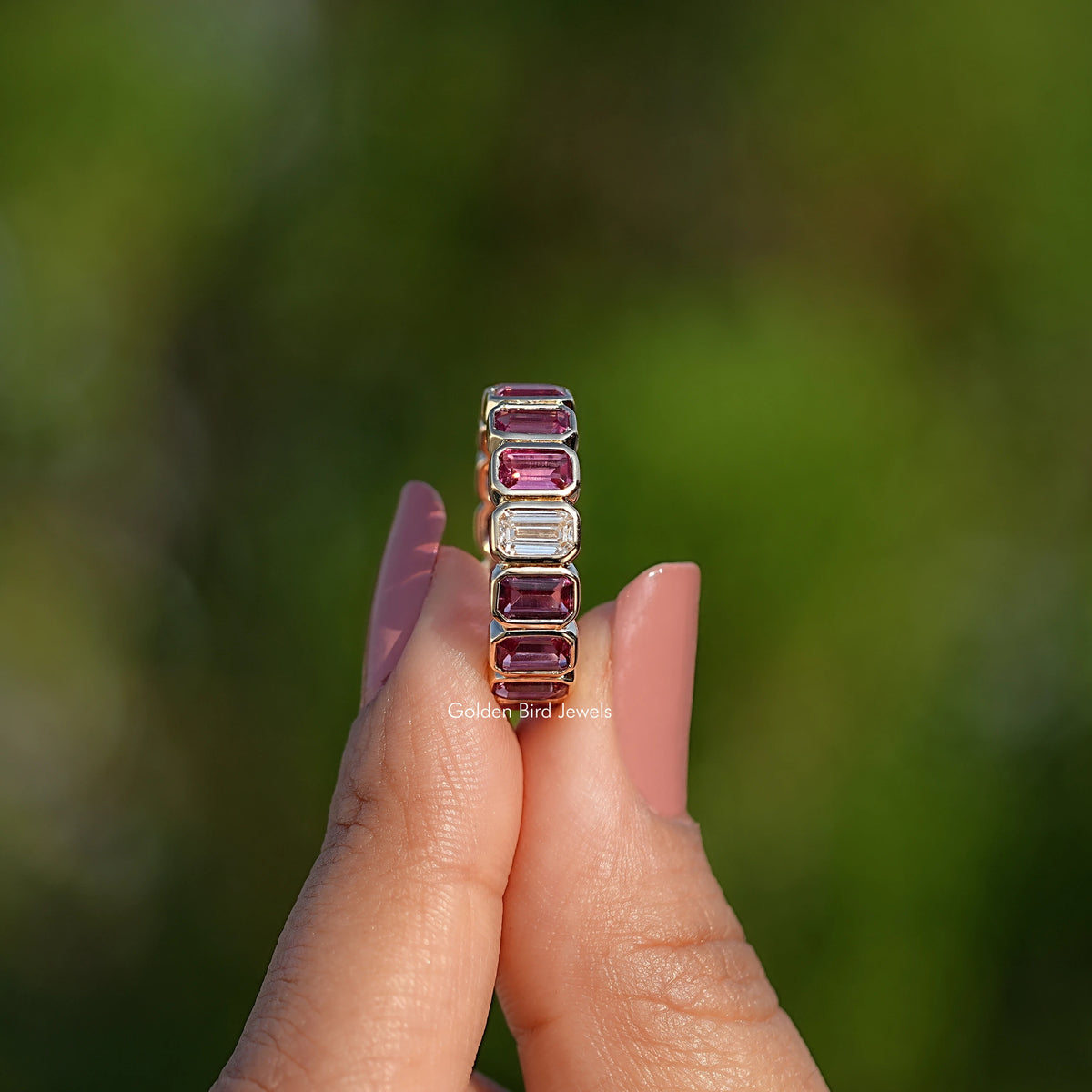 Bezel-set eternity band with rectangular pink-purple stones on a metal frame