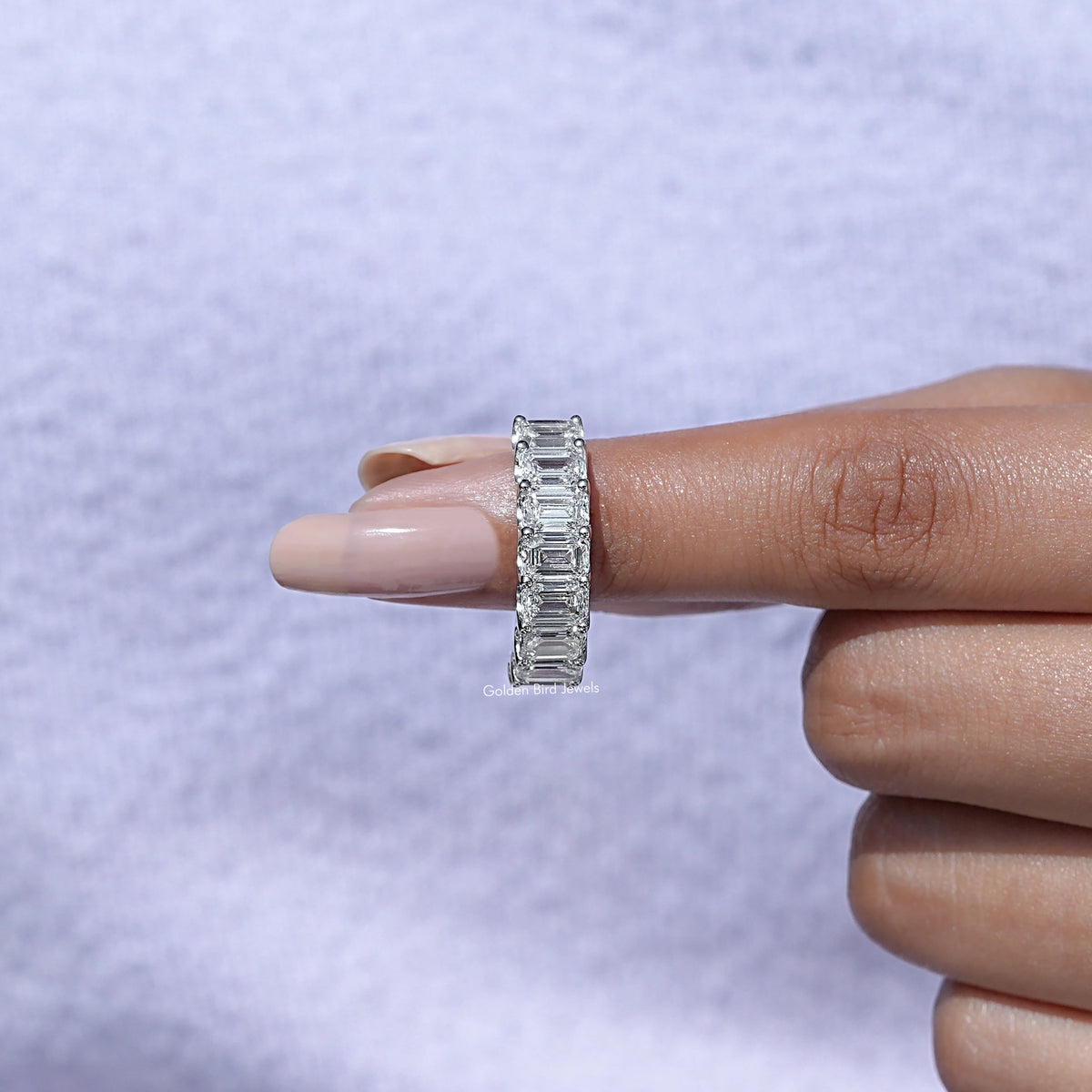 In finger front View of Emerald Cut Diamond Eternity Band In White Gold