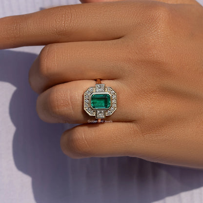 Gold-tone halo engagement ring with emerald-green center stone and square crystal halo