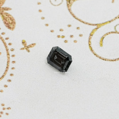 Loose dark gray emerald-cut moissanite gemstone, faceted