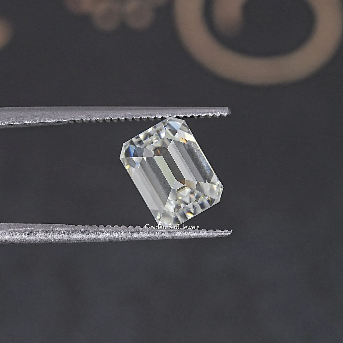 Loose emerald-cut moissanite stone shown from a slight side angle, clear