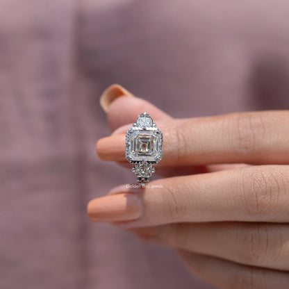 Asscher-cut center moissanite with round side stones, prong-set ring close-up