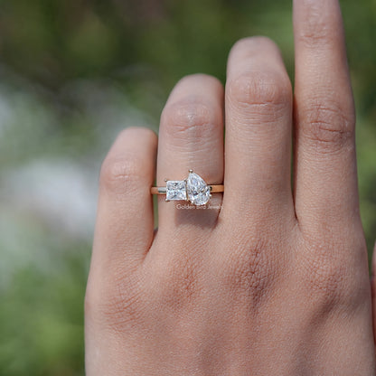 Toi et moi moissanite ring on hand with pear and princess-cut stones