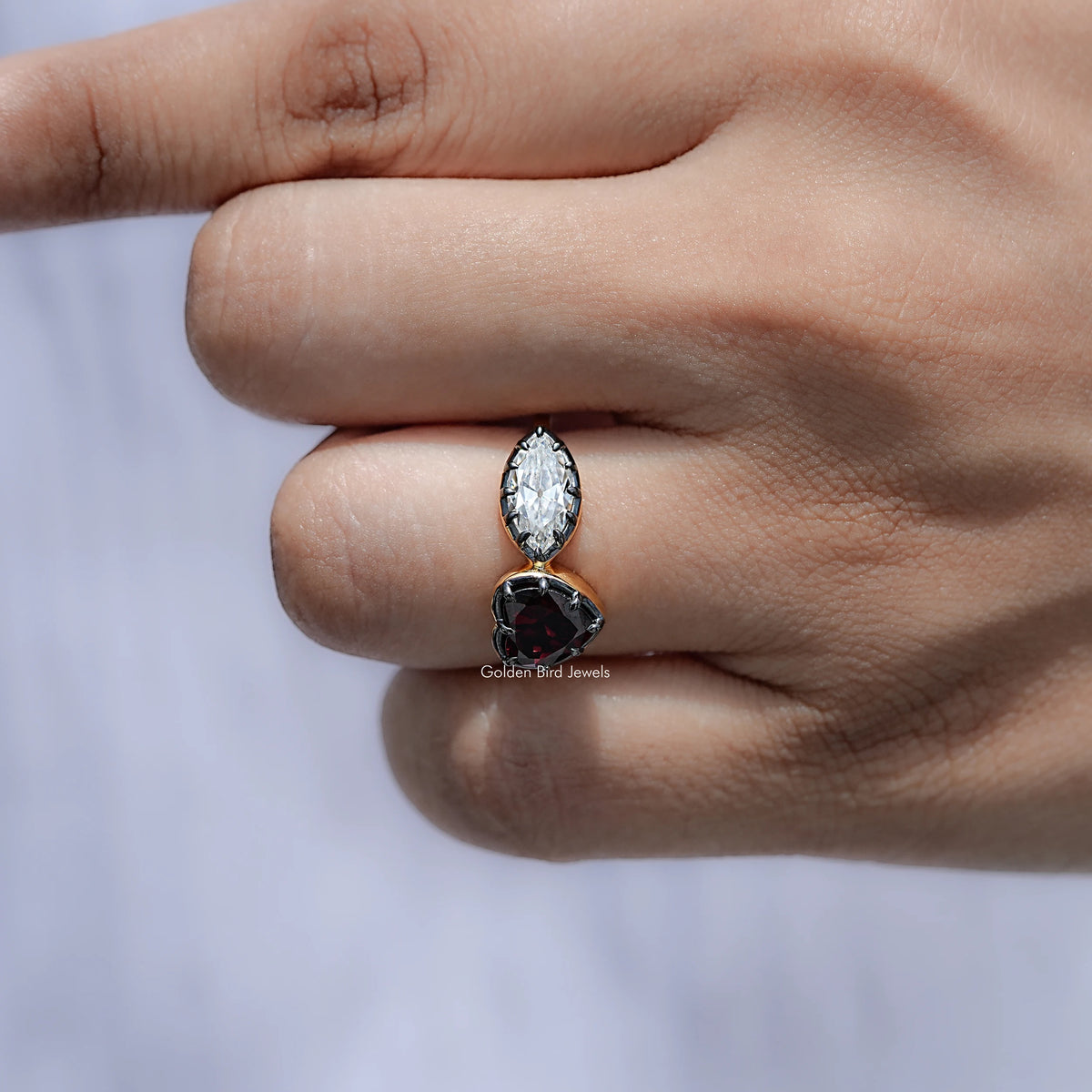 Side profile of heart two-stone ring: oval clear gemstone with dark heart setting