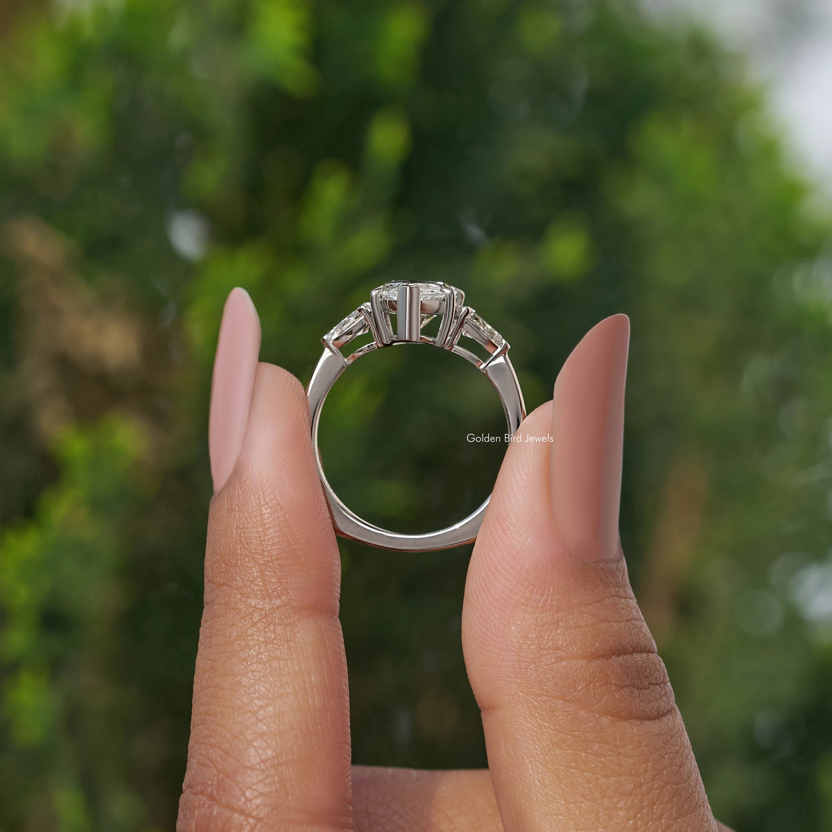 Three-stone pear-cut diamond engagement ring, underside view of prongs and band