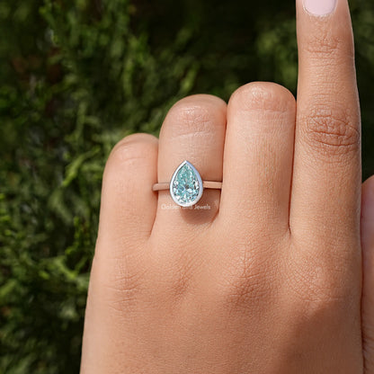 Sterling silver bezel-set pear-cut moissanite solitaire ring on hand