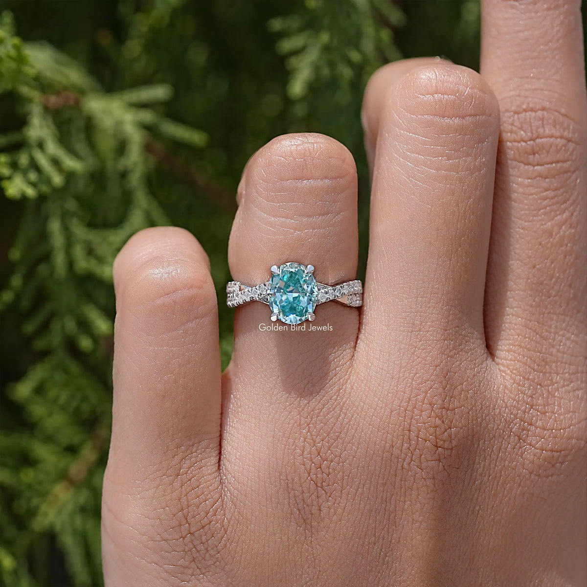 Sterling silver ring with oval blue moissanite center and slim pave band