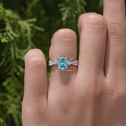 Sterling silver ring with oval blue moissanite center and slim pave band
