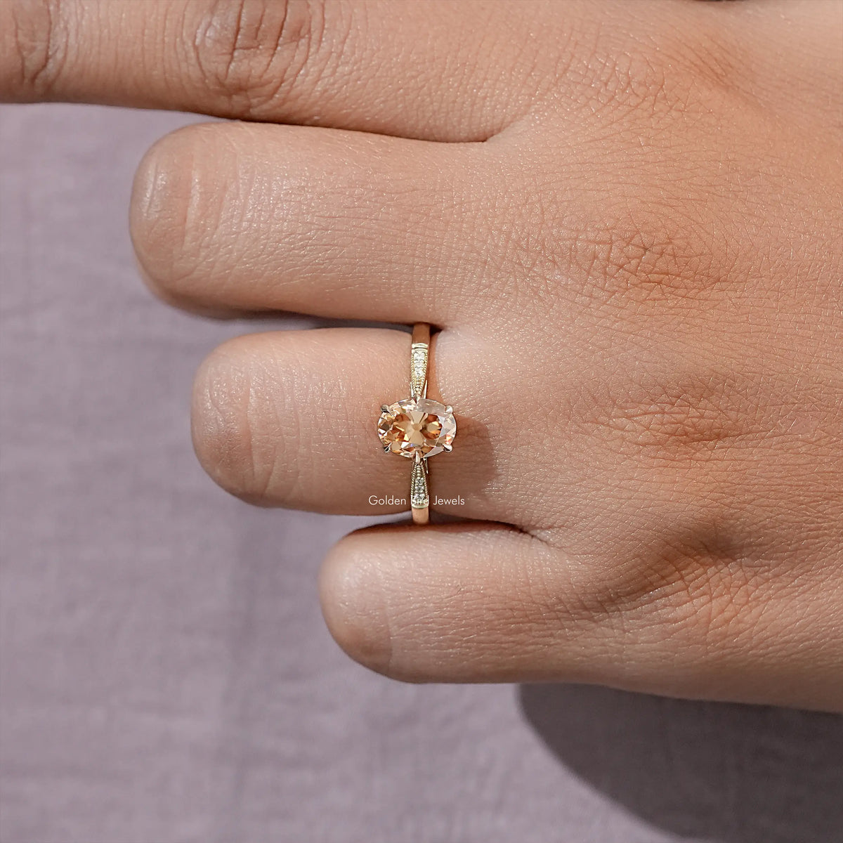 Gold-tone oval solitaire ring close-up on hand