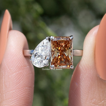 Toi et moi ring close-up with pear white moissanite and square warm brown center