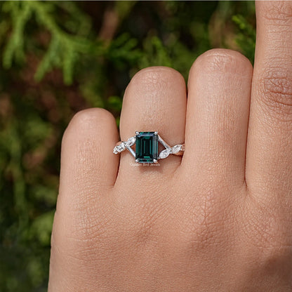 Sterling silver green emerald-cut moissanite ring with small floral side stones.