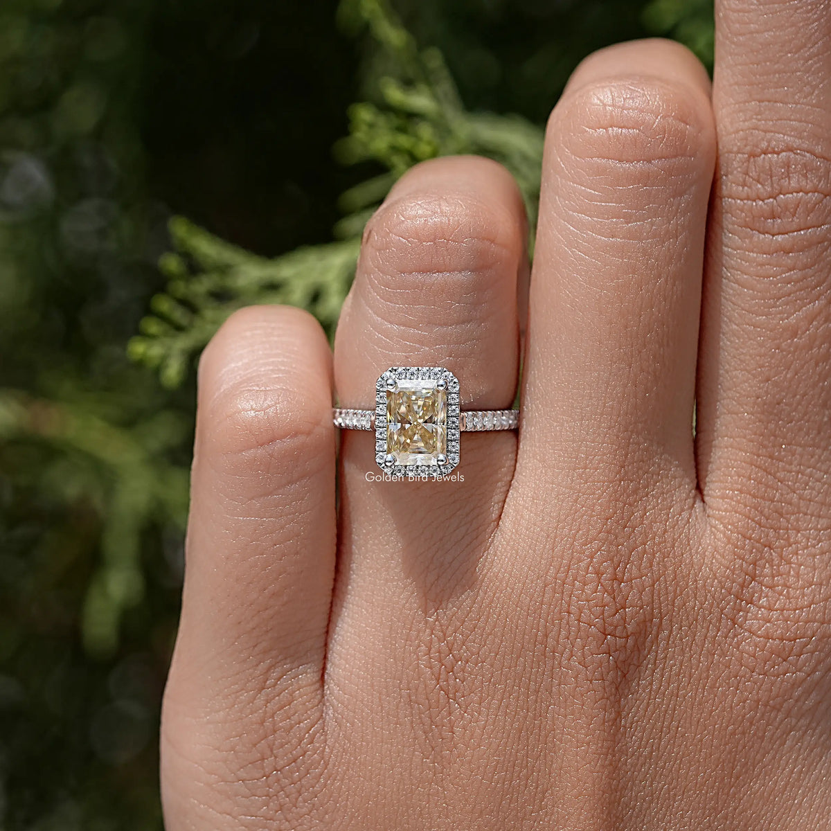 Radiant cut moissanite halo wedding ring in silver on a hand