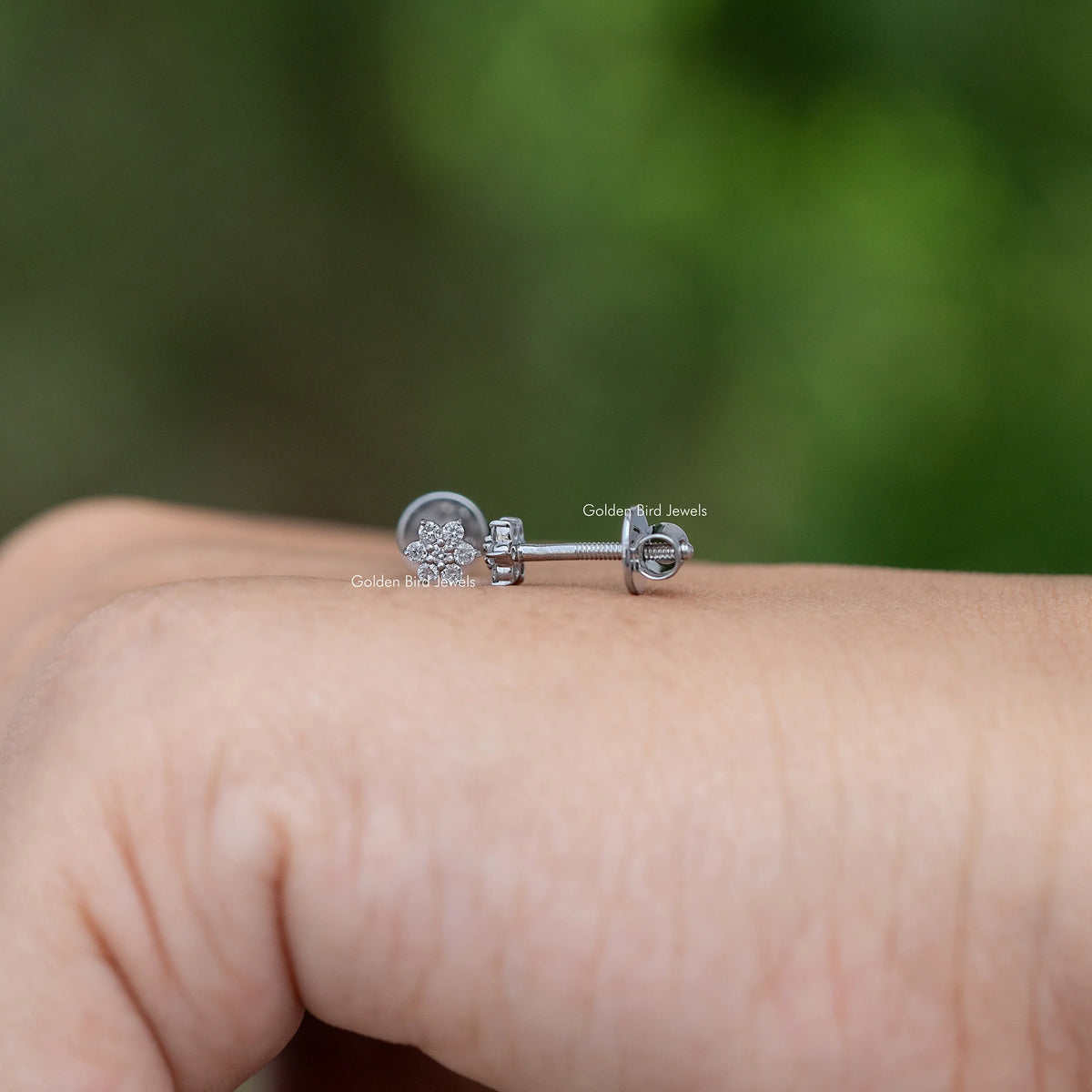 Floral diamond stud earrings with butterfly back and round stone cluster, silver-tone.