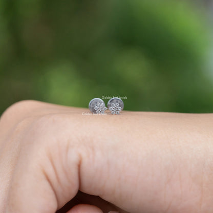 Floral-shaped diamond stud earrings, round stone cluster in silver-tone setting.