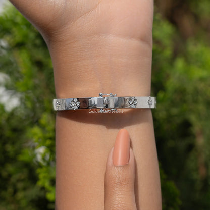 Silver bangle bracelet with three floral diamond accents and slim polished band