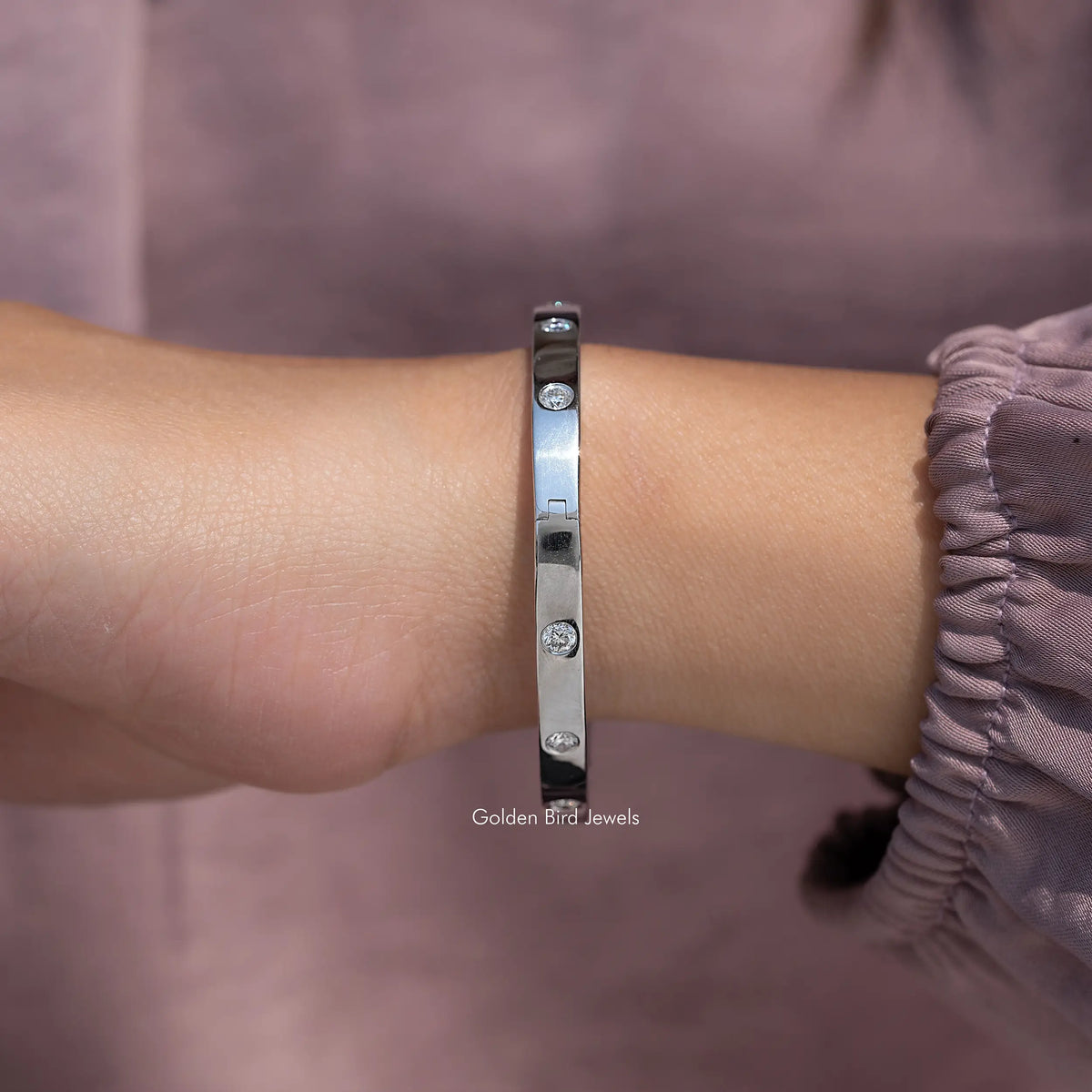 Silver round lab diamond flush-set bangle, close-up side view on wrist