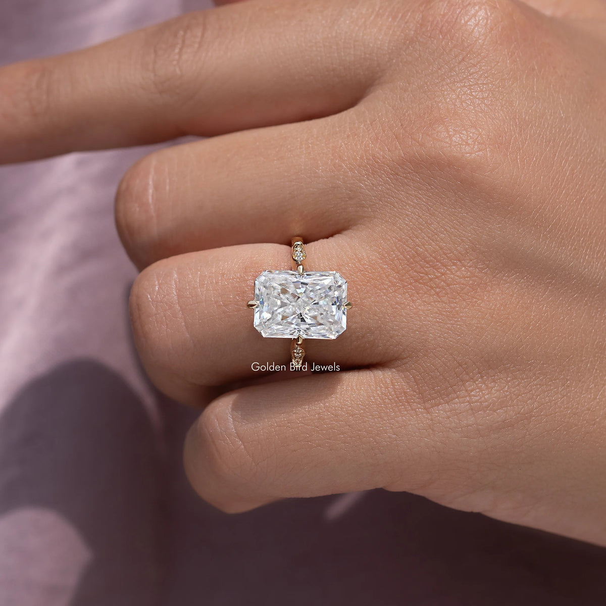 Rectangular-cut engagement ring center stone on slim band, close-up