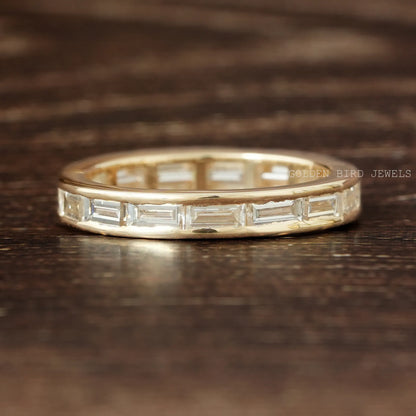 Gold eternity band ring with baguette-cut clear stones in full metal bezel