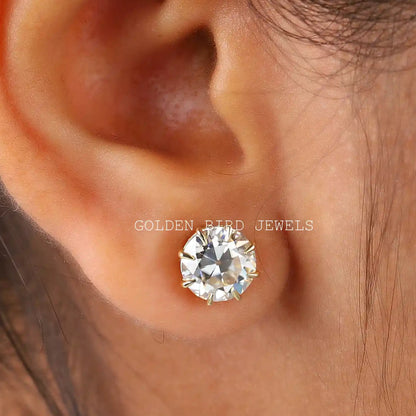 Round moissanite stud earring with prong-set round clear stone, shown on ear