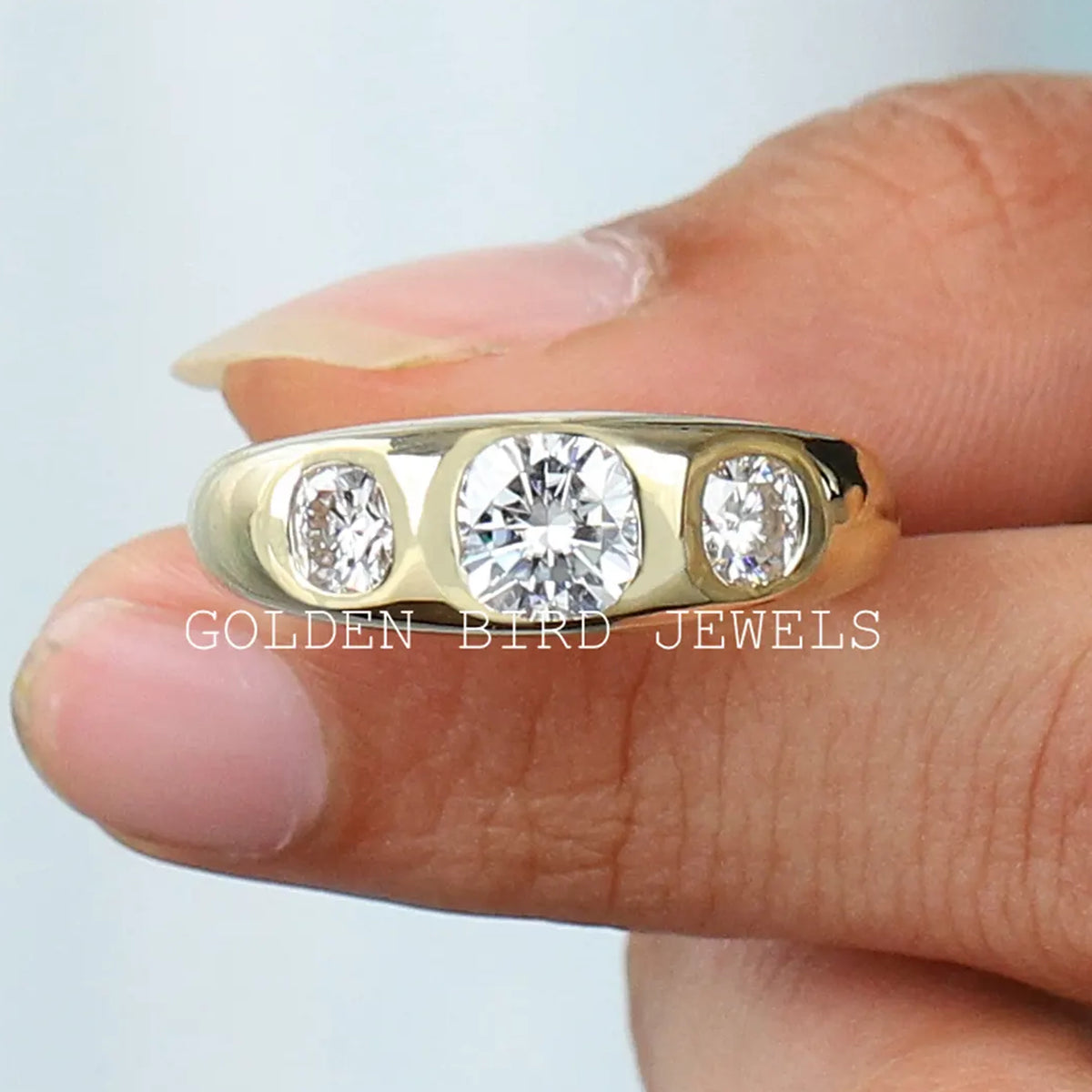 Three-stone cushion-cut moissanite men's ring with gold-tone band and three bright stones