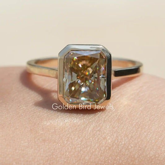 Radiant-cut moissanite solitaire ring with rectangular gold center stone