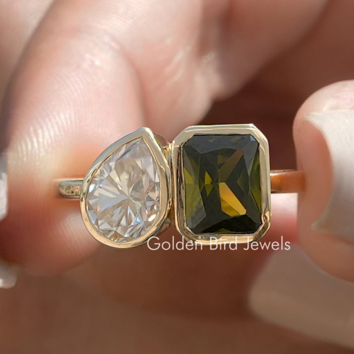 Two-stone bezel ring with clear and smoky pear-cut gemstones on polished gold band