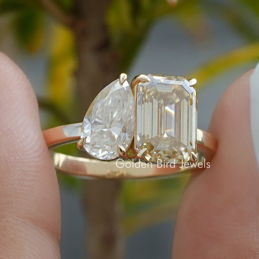 Close-up of two-stone toi et moi ring with pear-shaped and emerald-cut prong-set stones