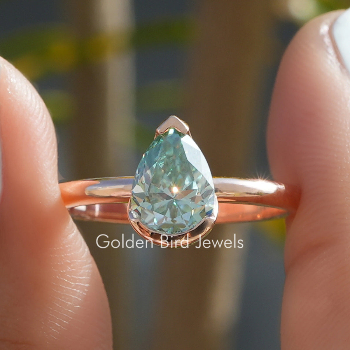 Gold-tone pear cut solitaire ring with V-prong setting and teardrop gemstone