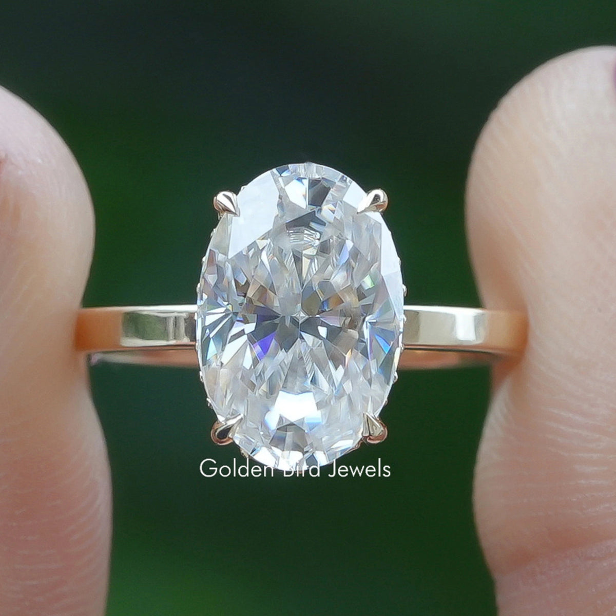 Oval-cut solitaire ring with faceted center stone and four-prong setting