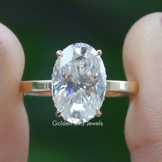 Oval-cut solitaire ring with faceted center stone and four-prong setting