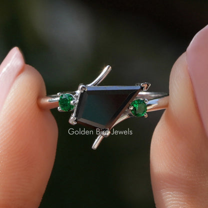 Kite-cut moissanite engagement ring with black center stone and two green side stones