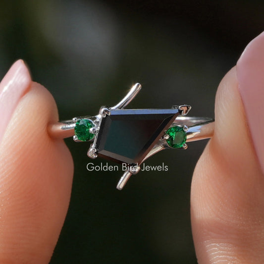 Kite-cut moissanite engagement ring with black center stone and two green side stones