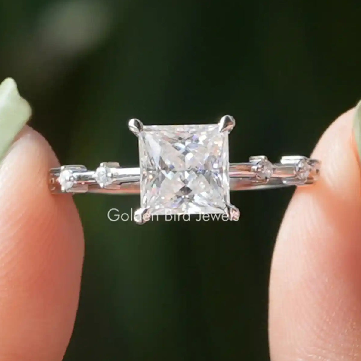 Colorless princess-cut solitaire proposal ring with prong-set center and baguette side accents