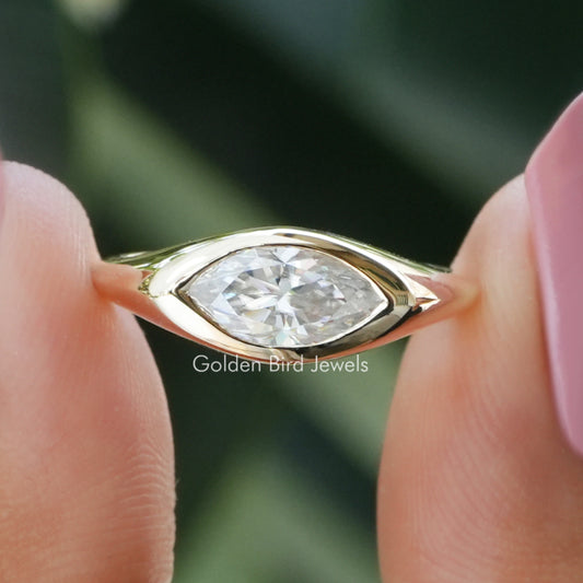 Gold-tone marquise-cut bezel-set moissanite ring with clear center stone