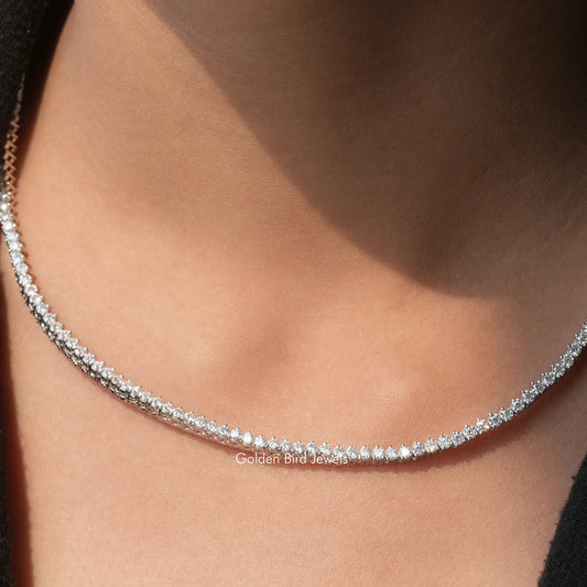 Silver round moissanite tennis necklace with small round stones, close-up on neck