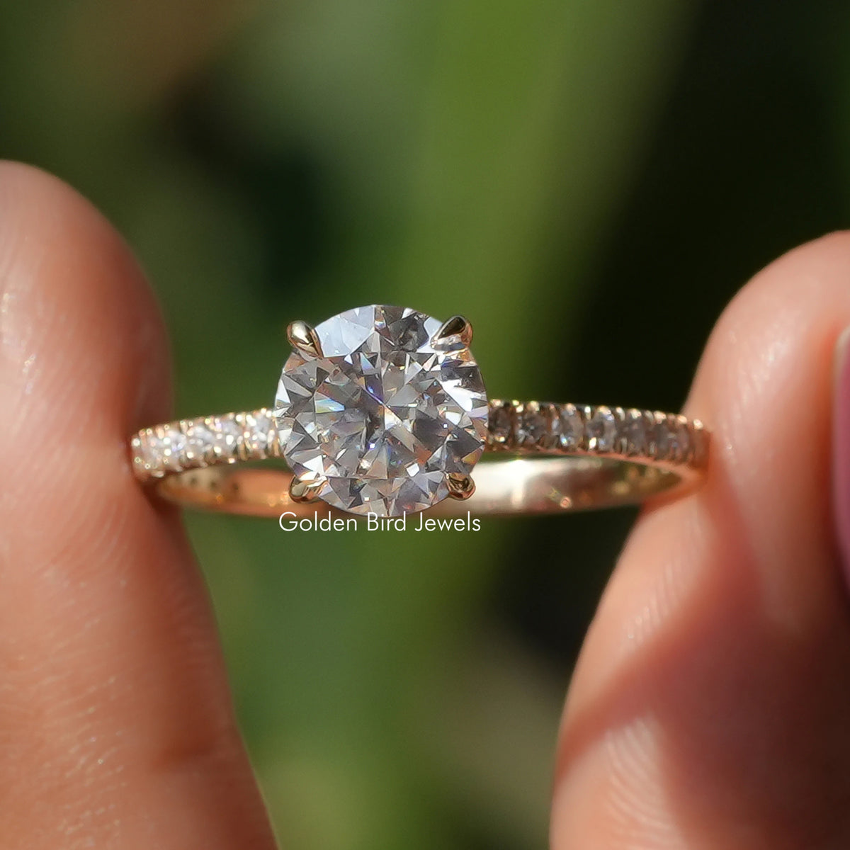 Round-cut moissanite solitaire ring with accent stones on a slender gold band