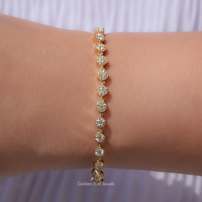 Gold tennis bracelet with round-cut moissanite stones, linked on the wrist