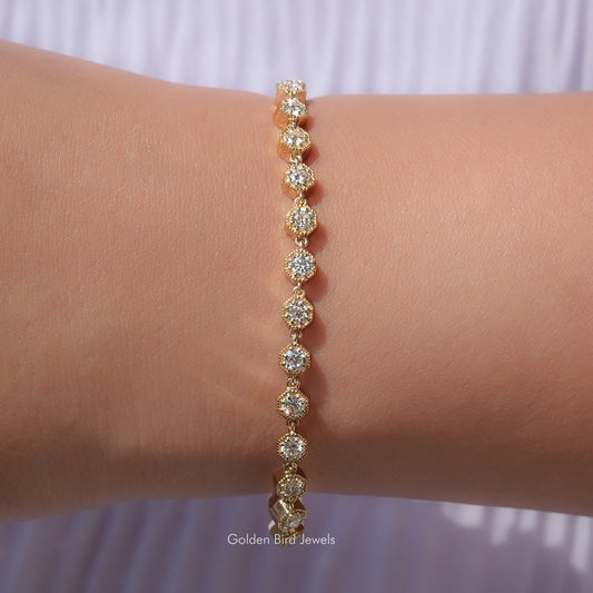 Gold tennis bracelet with round-cut moissanite stones, linked on the wrist