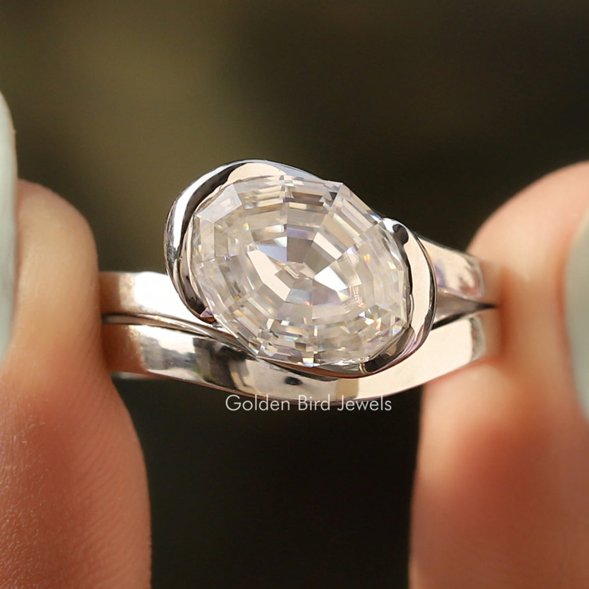 Oval moissanite bypass ring, curved polished silver band with bezel-set stone