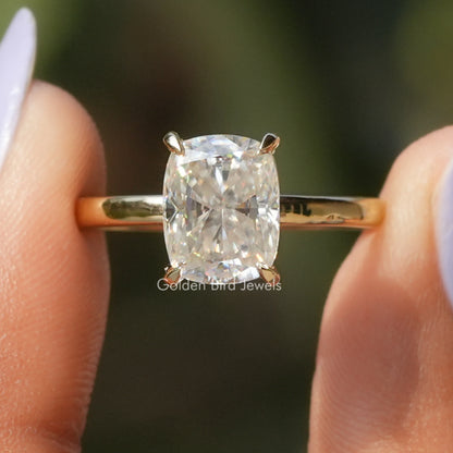 Gold-tone engagement ring with elongated cushion-cut moissanite center stone, four-prong setting
