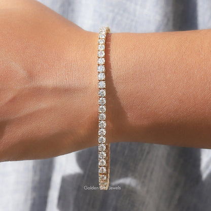 Moissanite tennis bracelet with round-cut stones, gold-tone, centered on wrist